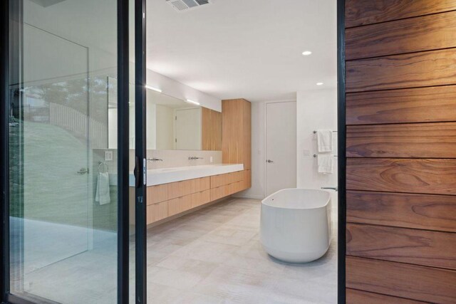 105 Scamper Cv, Lakeway, TX 78734 - full bathroom featuring double vanity, a shower stall, and a freestanding bath