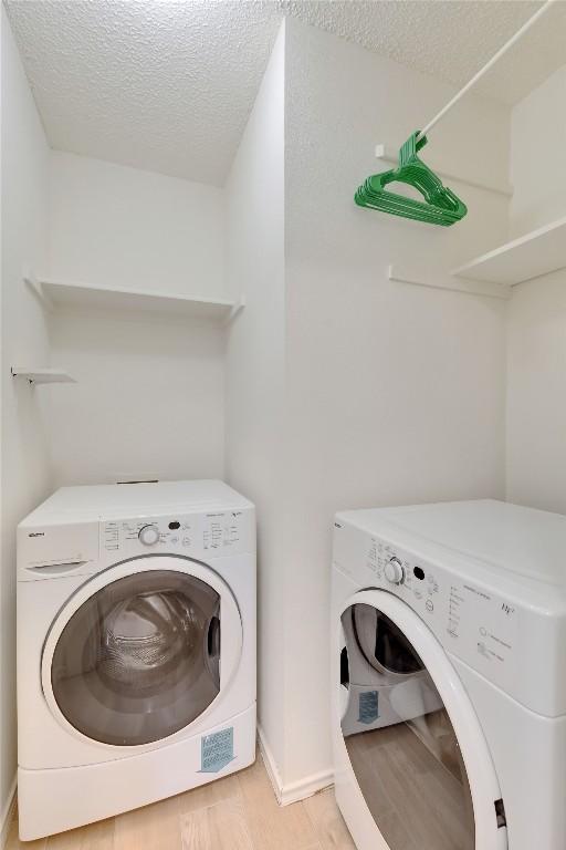 2009 Barnett Dr, Cedar Park, TX 78613 - washroom featuring independent washer and dryer, a textured ceiling, light wood-style floors, and baseboards