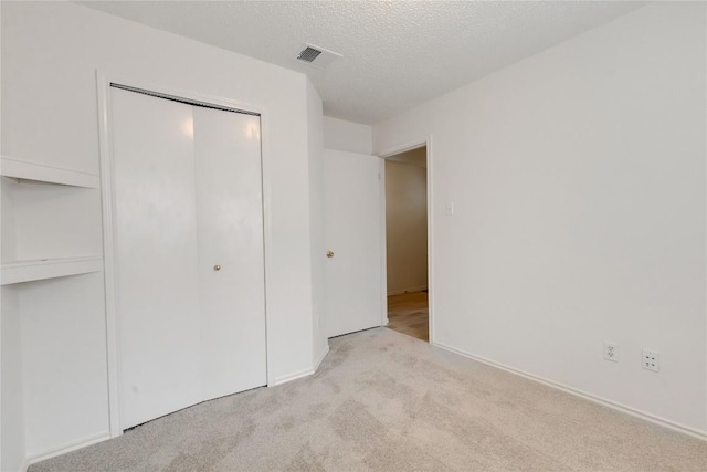2009 Barnett Dr, Cedar Park, TX 78613 - unfurnished bedroom with carpet flooring, a closet, a textured ceiling, and baseboards
