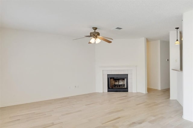 2009 Barnett Dr, Cedar Park, TX 78613 - unfurnished living room with light wood-style flooring, a ceiling fan, a fireplace, and baseboards
