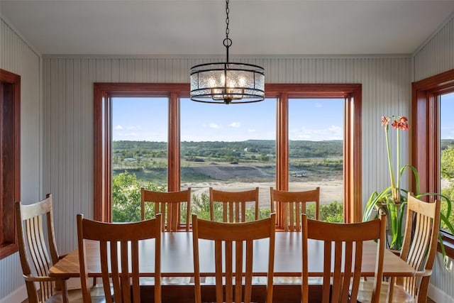 dining area with a notable chandelier and wallpapered walls