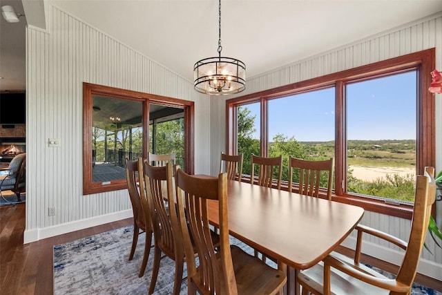 dining space featuring plenty of natural light, an inviting chandelier, wood finished floors, and baseboards