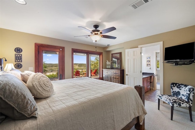 bedroom with ensuite bath, access to outside, light carpet, ceiling fan, and visible vents