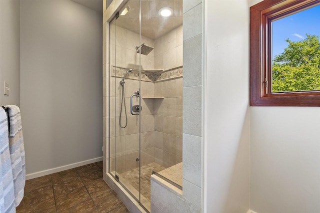 bathroom featuring a stall shower and baseboards
