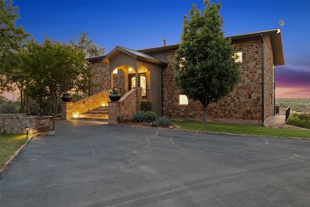 view of front facade featuring driveway and stone siding