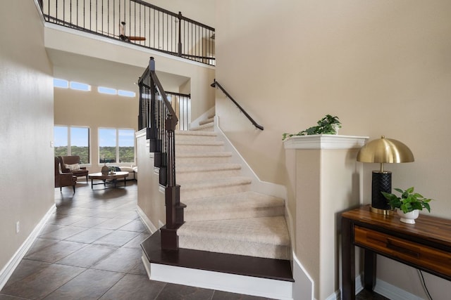 3207 Crystal Falls Pkwy, Leander, TX 78641 - stairway featuring baseboards, a high ceiling, and tile patterned flooring
