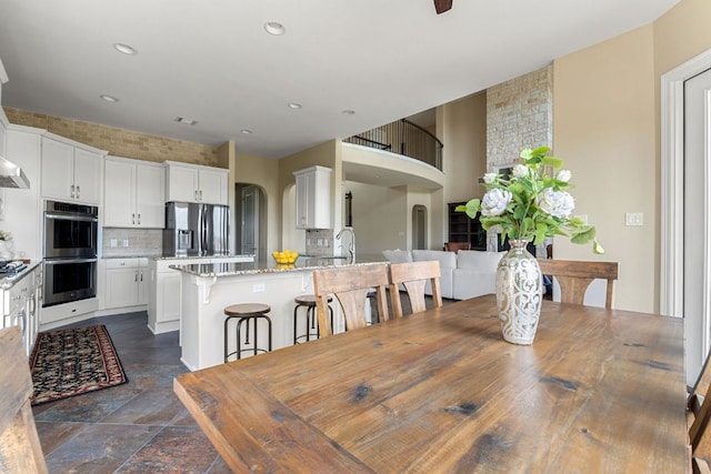 3207 Crystal Falls Pkwy, Leander, TX 78641 - dining room with recessed lighting, arched walkways, and stone finish flooring
