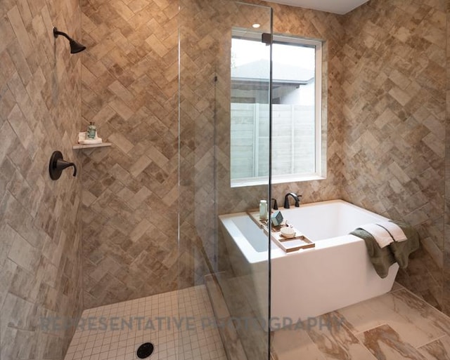 321 Dycus Bnd, Liberty Hill, TX 78642 - full bathroom featuring a garden tub, a tile shower, and tile walls