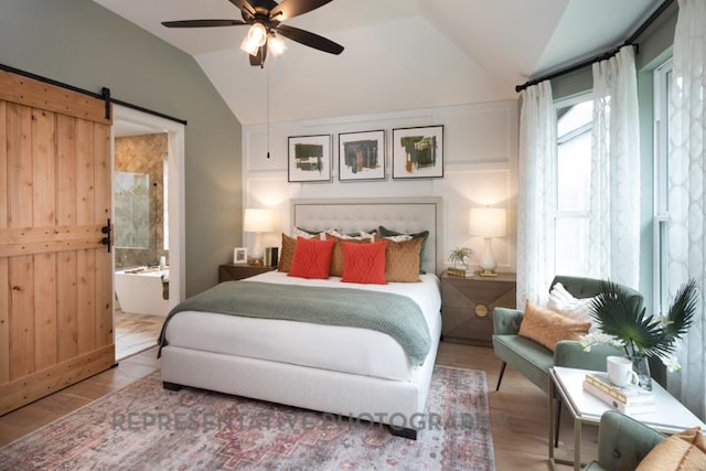 321 Dycus Bnd, Liberty Hill, TX 78642 - bedroom featuring lofted ceiling, wood finished floors, ceiling fan, ensuite bath, and a barn door
