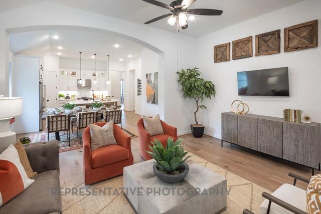 321 Dycus Bnd, Liberty Hill, TX 78642 - living room with arched walkways, a ceiling fan, light wood-style floors, and recessed lighting