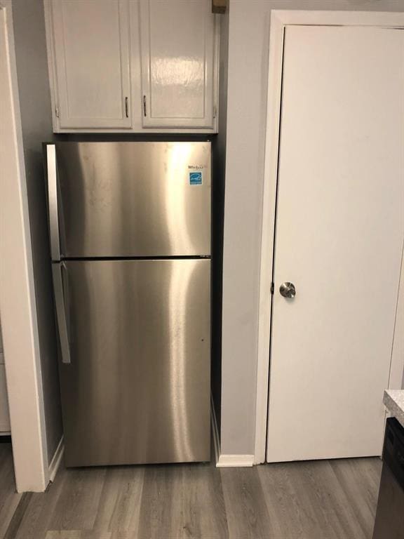 2815 Rio Grande St Unit 201, Austin, TX 78705 - kitchen featuring baseboards, white cabinetry, light countertops, freestanding refrigerator, and wood finished floors