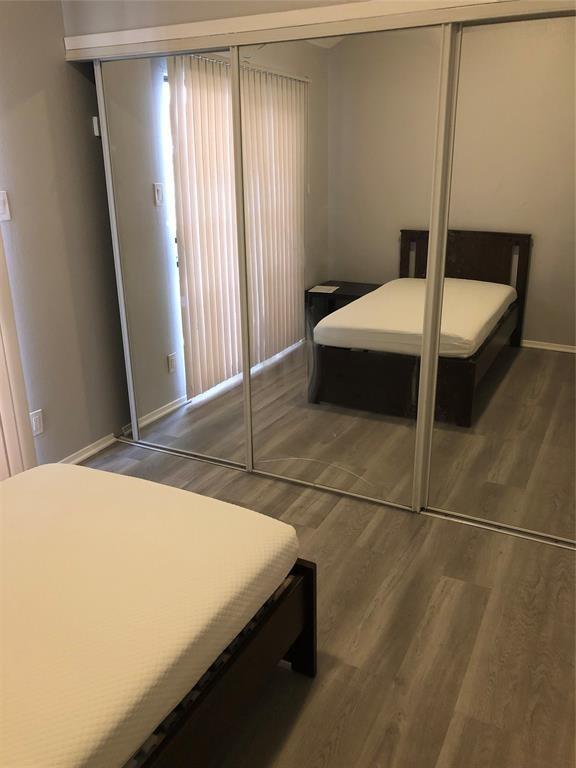 2815 Rio Grande St Unit 201, Austin, TX 78705 - bedroom with baseboards, wood finished floors, and a closet