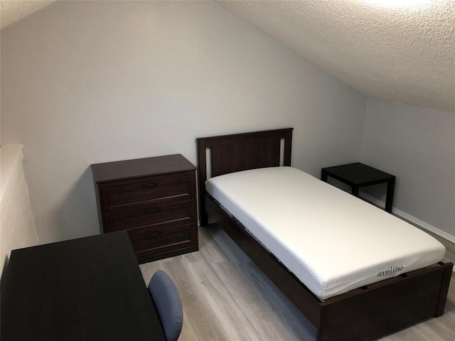2815 Rio Grande St Unit 201, Austin, TX 78705 - bedroom with a textured ceiling, light wood finished floors, and vaulted ceiling