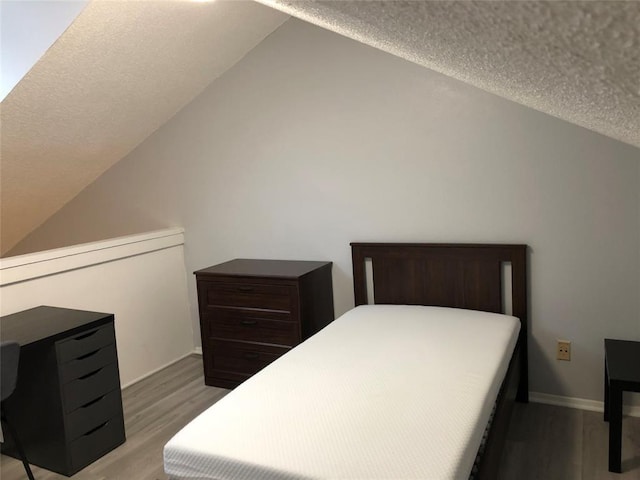 2815 Rio Grande St Unit 201, Austin, TX 78705 - bedroom with a textured ceiling, wood finished floors, and lofted ceiling