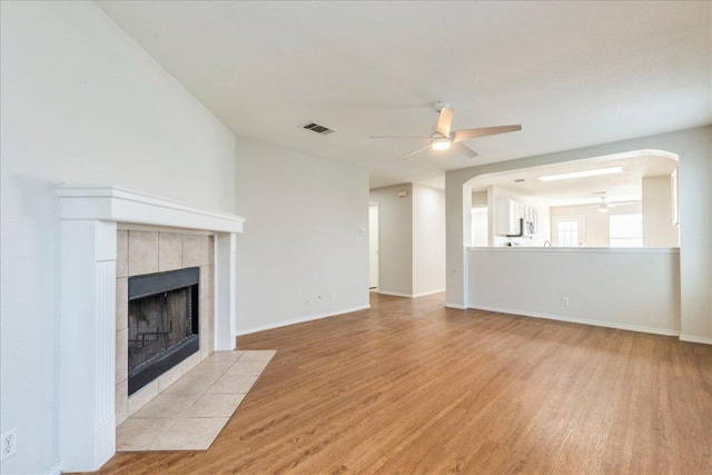 109 David Dr, Hutto, TX 78634 - unfurnished living room featuring visible vents, light wood-type flooring, ceiling fan, and a fireplace