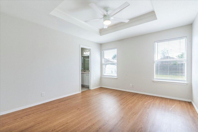 109 David Dr, Hutto, TX 78634 - spare room with light wood-style floors, ceiling fan, a tray ceiling, crown molding, and baseboards