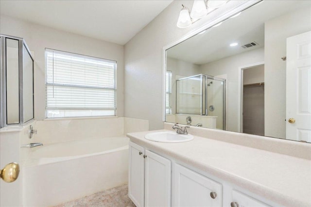 109 David Dr, Hutto, TX 78634 - full bath featuring a garden tub, vanity, a shower stall, and a walk in closet
