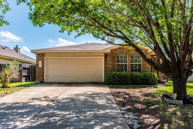 109 David Dr, Hutto, TX 78634 - view of front of home featuring concrete driveway, fence, an attached garage, and brick siding