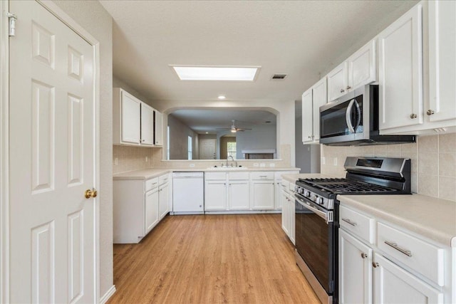 109 David Dr, Hutto, TX 78634 - kitchen with stainless steel appliances, light countertops, light wood-type flooring, white cabinetry, and backsplash
