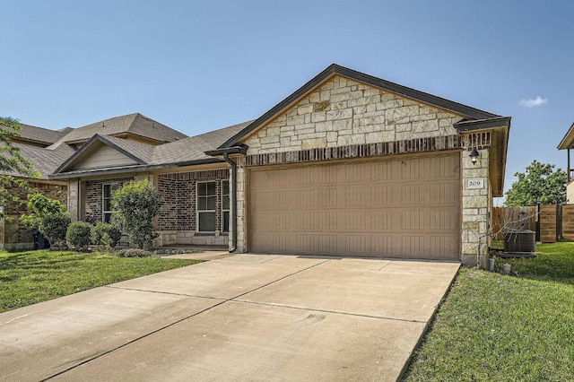 single story home with driveway, a front lawn, an attached garage, and stone siding