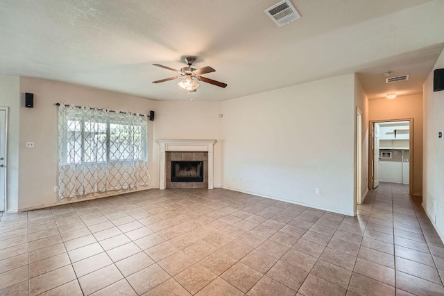 unfurnished living room featuring a tile fireplace, ceiling fan, light tile patterned floors, and visible vents