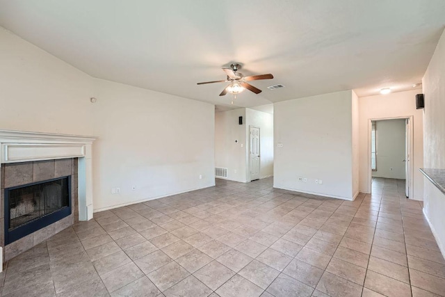 unfurnished living room with light tile patterned floors, ceiling fan, visible vents, baseboards, and a tile fireplace