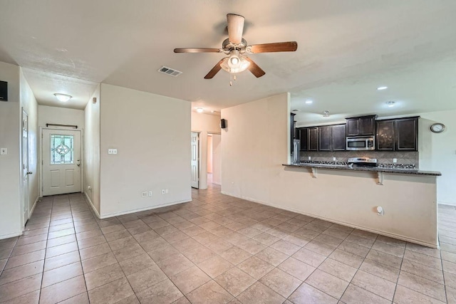 unfurnished living room featuring baseboards, visible vents, light tile patterned floors, and a ceiling fan
