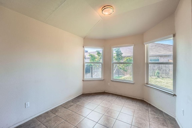 empty room with light tile patterned flooring and baseboards
