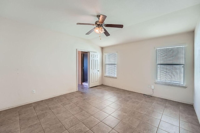 empty room featuring a ceiling fan, light tile patterned flooring, and lofted ceiling