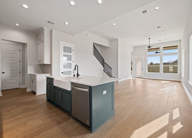 109 Flora Springs Cv, Liberty Hill, TX 78642 - kitchen featuring stainless steel dishwasher, a sink, light wood finished floors, recessed lighting, and light countertops