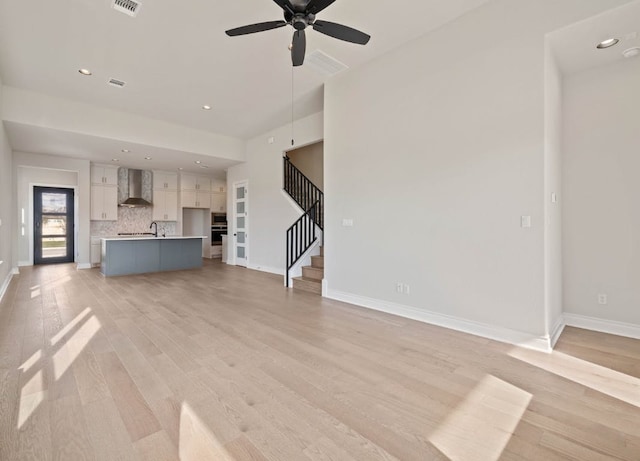 109 Flora Springs Cv, Liberty Hill, TX 78642 - unfurnished living room featuring ceiling fan, light wood-style flooring, stairs, baseboards, and recessed lighting