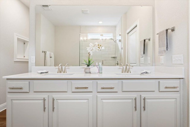 full bath with a sink, a shower stall, double vanity, and visible vents