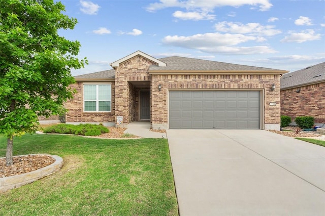 ranch-style home featuring driveway, a front yard, roof with shingles, brick siding, and an attached garage