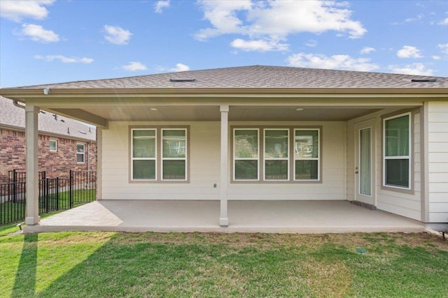 back of house featuring a lawn, fence, and a patio area