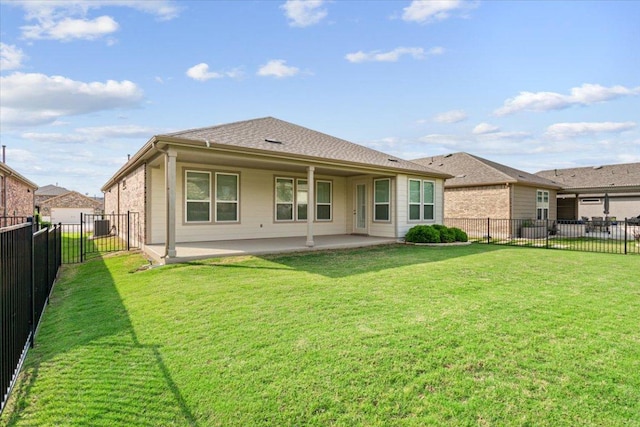back of house featuring a fenced backyard, a yard, and a patio area