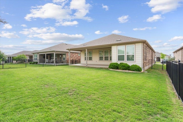 rear view of house with a patio, a fenced backyard, and a yard