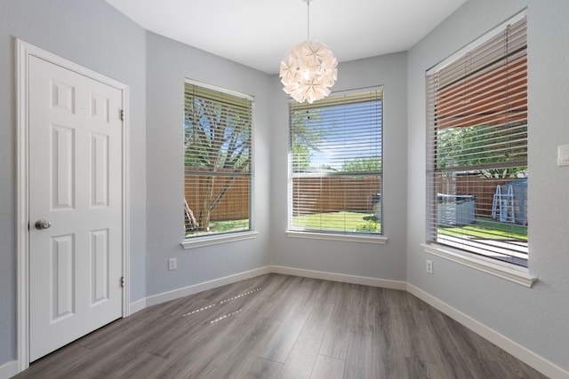 3322 Silk Oak Dr, Austin, TX 78748 - unfurnished dining area with a chandelier, wood finished floors, and baseboards