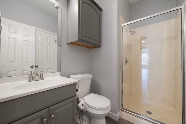full bathroom featuring a stall shower, toilet, and vanity