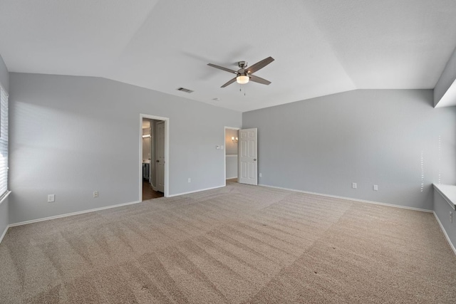 unfurnished bedroom with visible vents, vaulted ceiling, carpet floors, and baseboards