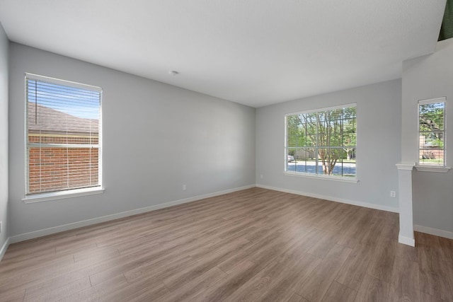 unfurnished living room with wood finished floors and baseboards