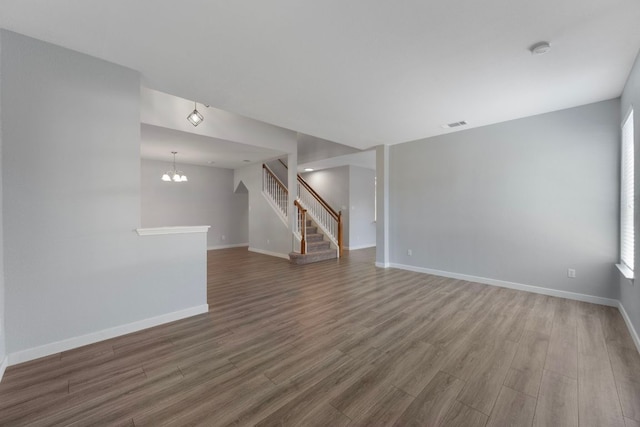 3322 Silk Oak Dr, Austin, TX 78748 - unfurnished living room with wood finished floors, baseboards, stairs, and a chandelier