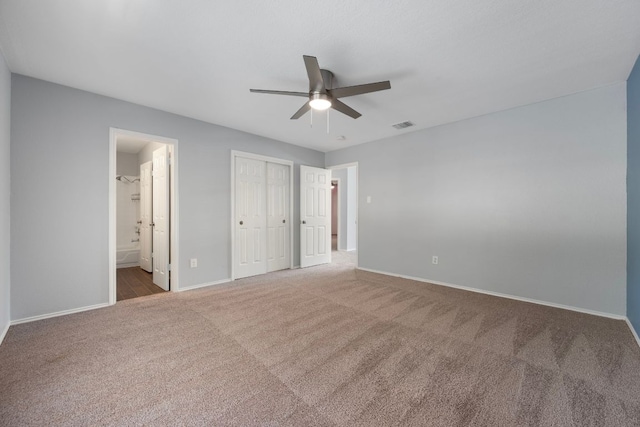 unfurnished bedroom with connected bathroom, a closet, visible vents, baseboards, and carpet floors