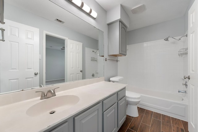 full bath with toilet, shower / bath combination, vanity, visible vents, and wood tiled floor