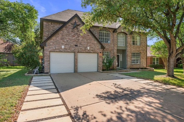 traditional-style house with brick siding, a front lawn, and driveway