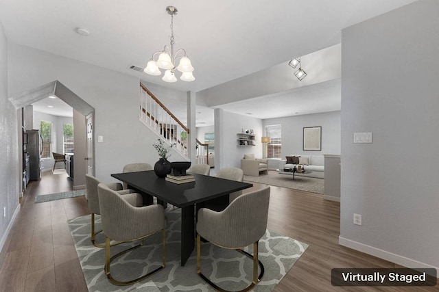 3322 Silk Oak Dr, Austin, TX 78748 - dining room featuring stairs, wood finished floors, baseboards, and a chandelier