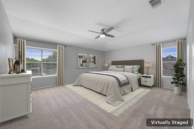 bedroom featuring baseboards, visible vents, a ceiling fan, and light carpet