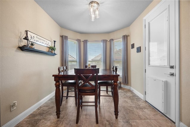 tiled dining area featuring baseboards