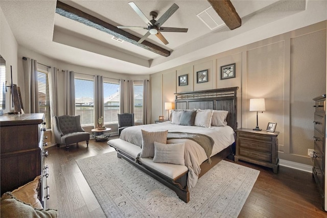 bedroom with visible vents, a ceiling fan, beamed ceiling, and dark wood-style floors