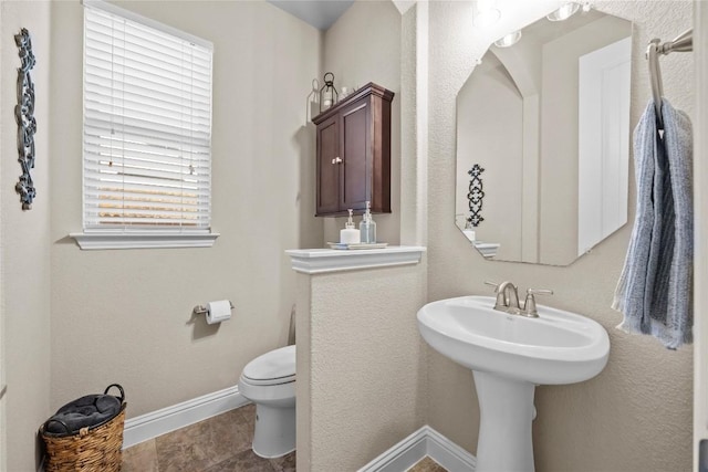 bathroom featuring toilet and baseboards