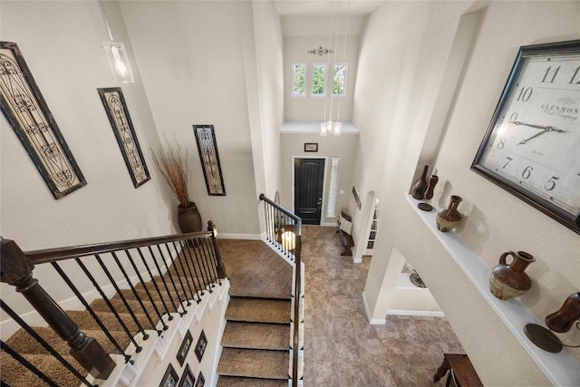 stairs featuring baseboards and a towering ceiling